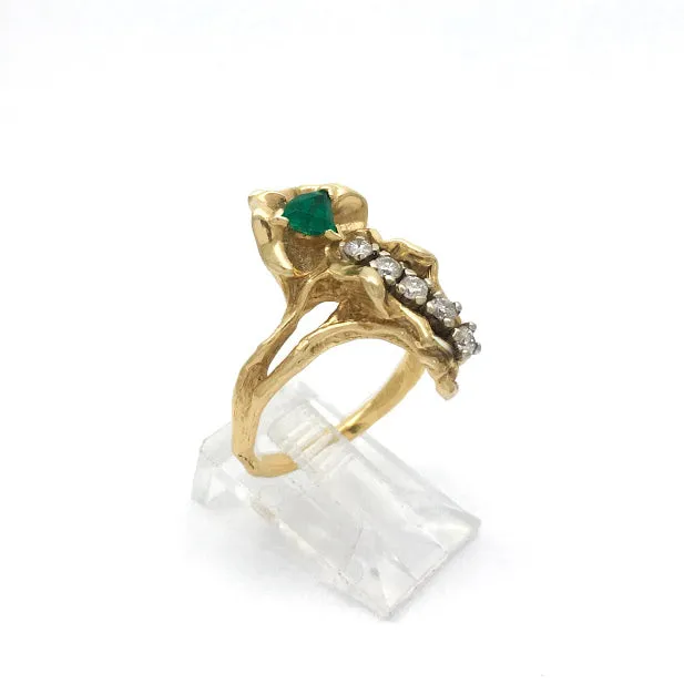 Blossom set with shield cut emerald with a line of five round diamonds